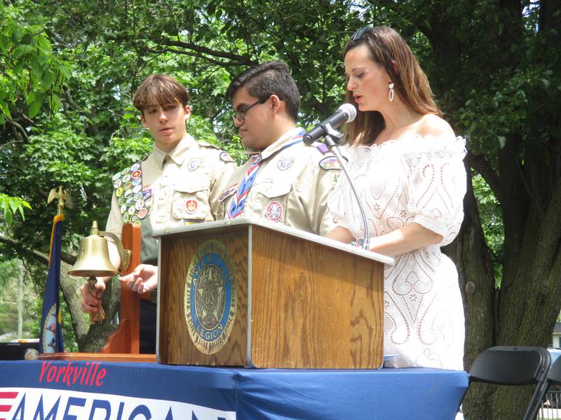 City of Yorkville Superintendent of Recreation Shay Remus reads the names of 61 Kendall County service members who made the ultimate sacrifice, during Memorial Day ceremonies on May 29, 2023 in Town Square Park. Sounding a bell in honor of each name is Boy Scout Troop 40's Paul Emmert, left, and Eric Montano.