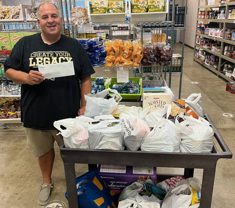 Spartan Food Pantry president Tomas Franks accepting Northern Rehab's food and school supply drive donations