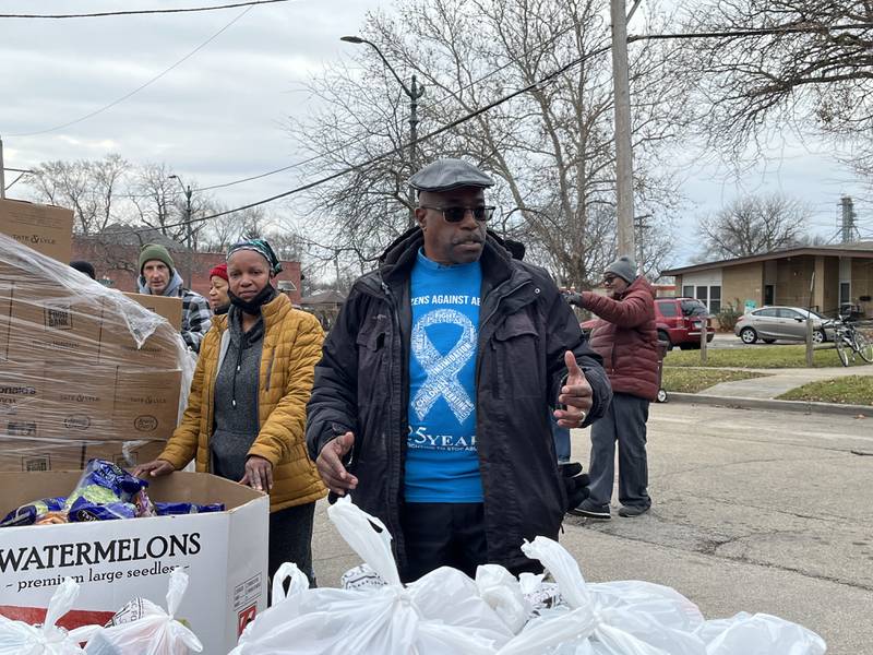 Rev. Elmer Harris, of Second Baptist Church in Joliet, works with volunteers for a food pantry event on Thursday, Dec. 21, near the church.