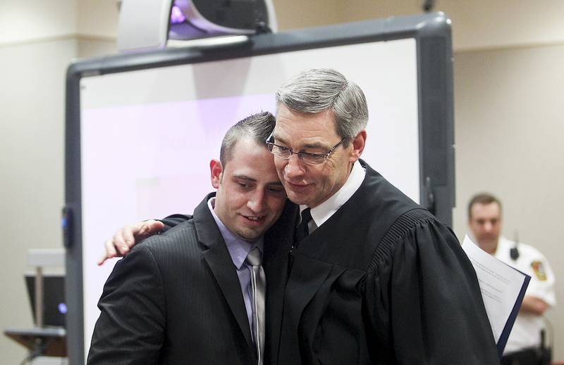 Drug Court graduate Ronnie Bianchi (left) receives a hug from Circuit Judge Charles P. Weech on Tuesday, May 13, 2014, during the 22nd Judicial Circuit Adult Drug Court commencement ceremony at the McHenry County Courthouse in Woodstock.