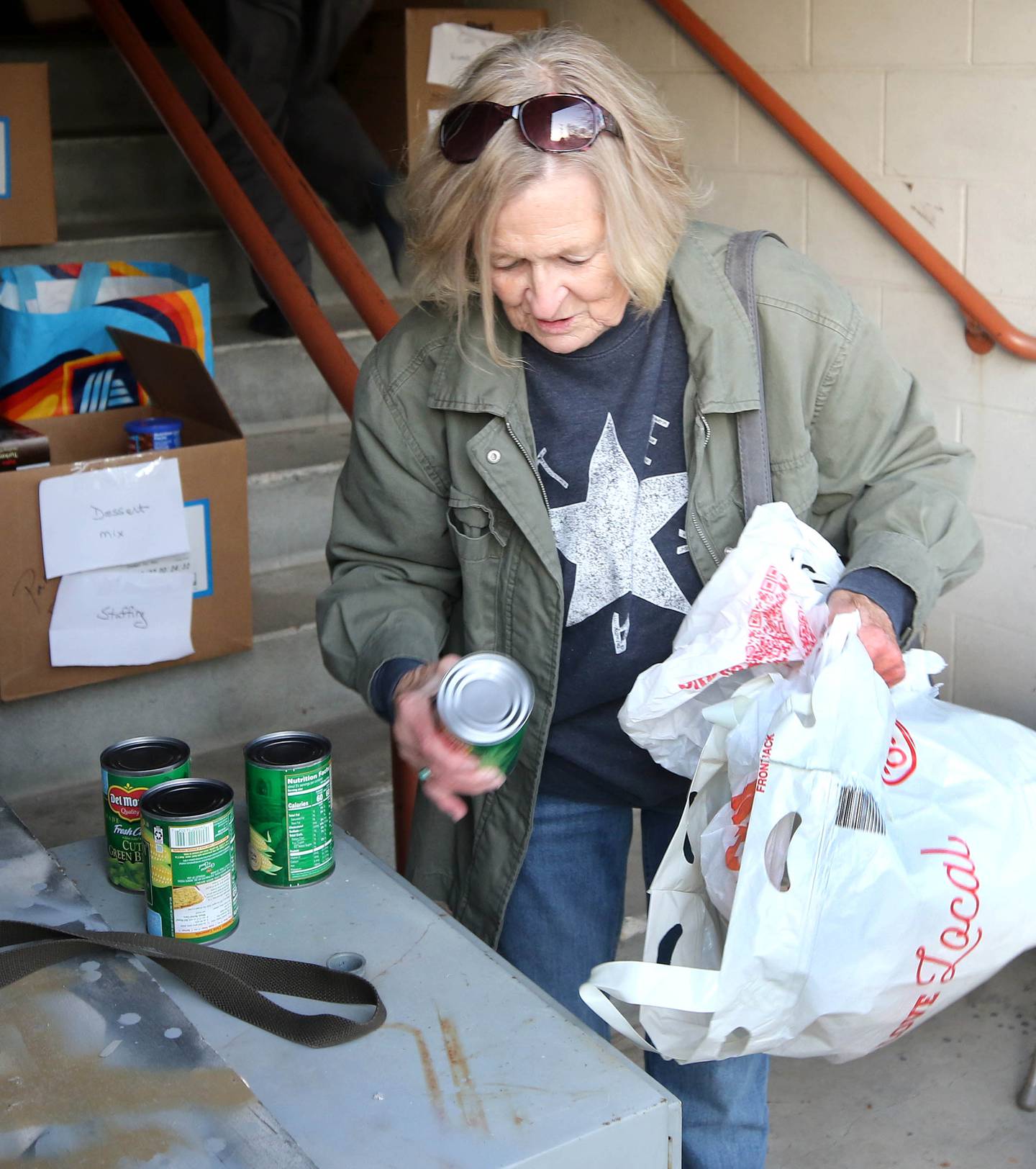 Kathy Cain, from Sycamore, takes items out of her bag for donation to the food drive Tuesday, Nov. 12, 2024, at the Stage Coach Theatre in Dekalb. The food collected will be assembled into dinner boxes to provide local families with a Thanksgiving meal.