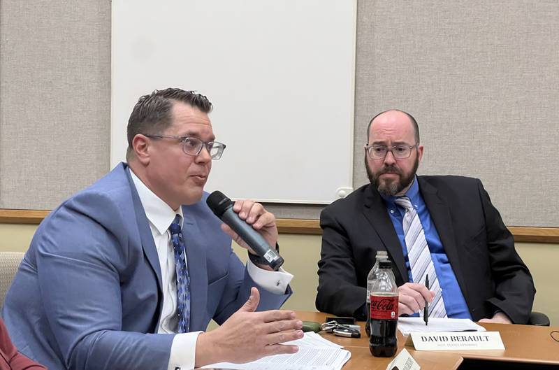 DeKalb County States Attorney David Berault, right, leans in as DeKalb County Administrator Brian Gregory talks about the final steps in the process of selling the DeKalb County Rehab and Nursing Center to Illuminate HC during the April 20, 2023 DeKalb County Board.