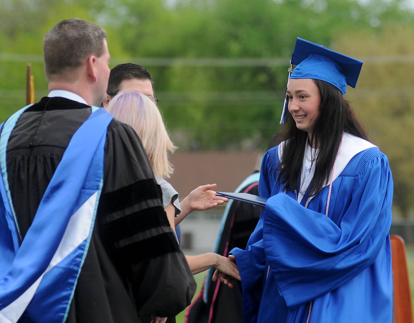 Emily Morgan Albrecht receives her diploma from school board members Sunday, May 15, 2022, during the Woodstock High School graduation ceremony in Woodstock.