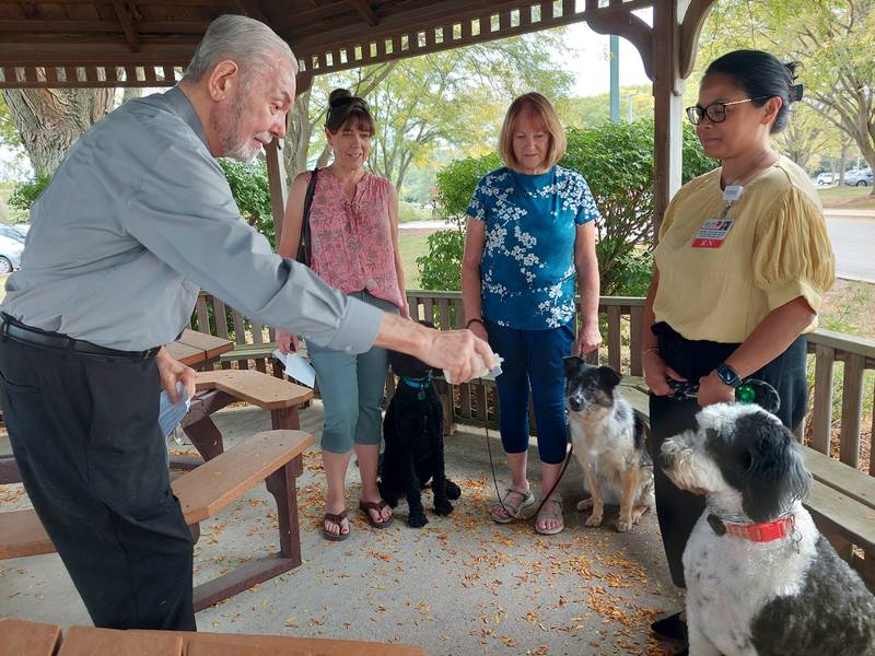 Deacon Ron Wackerlin blesses a trio of dogs (from left) Ernie with Nicole Wirtel; Rosie with Pat Pohl; Millie with Annabel Tomas on Wednesday, Oct. 4, 2023, at OSF St. Elizabeth in Ottawa, during the blessing of animals in celebration of St. Francis of Assisi.