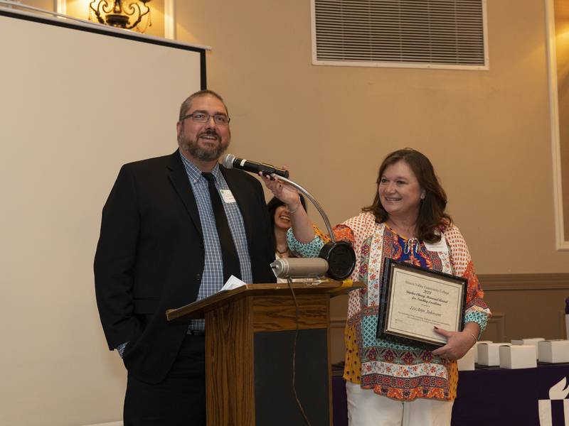 Stephen Charry Memorial Award for Teaching Excellence recipient LeeAnn Johnson listens to a tribute from colleague and former student Keith King at the recent Recognition Awards Event in Utica.