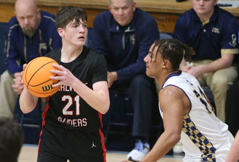 Earlville's Landen Tirevold looks to pass the ball around Marquette's Tray Alford on Friday, Jan. 3, 2025 in Bader Gym at Marquette High School.