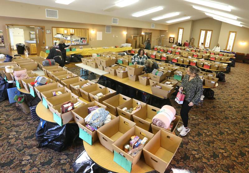 Volunteers fill baskets on Thursday, Dec, 14, 2023 at the Putnam County Food Pantry in Granville. In collaboration with Toys in the Pantry, organizations, businesses, churches and schools from across the county the pantry is distributing over 100 Christmas baskets to local families in need. This is the 36th year the pantry has sponsored the basket project. The baskets contain food and gifts for children and senior citizens.