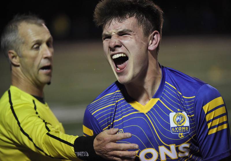 Lyons Township’s Collin Sullivan is held back by a referee as he celebrates the Lions win against Naperville North in the Class 3A state soccer semifinal game in Hoffman Estates on Friday, November 3, 2023.