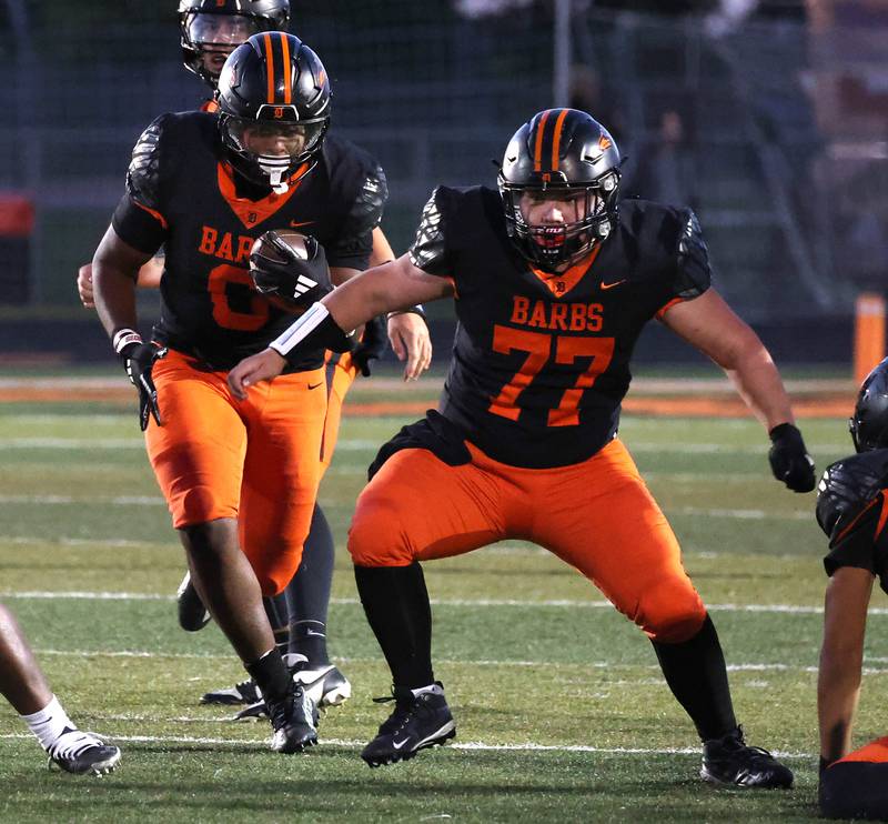 DeKalb's Travis Moore follows offensive lineman Brayden Ryder through the hole in the Phillips line Friday, Sept. 5, 2025, during their game at DeKalb High School.