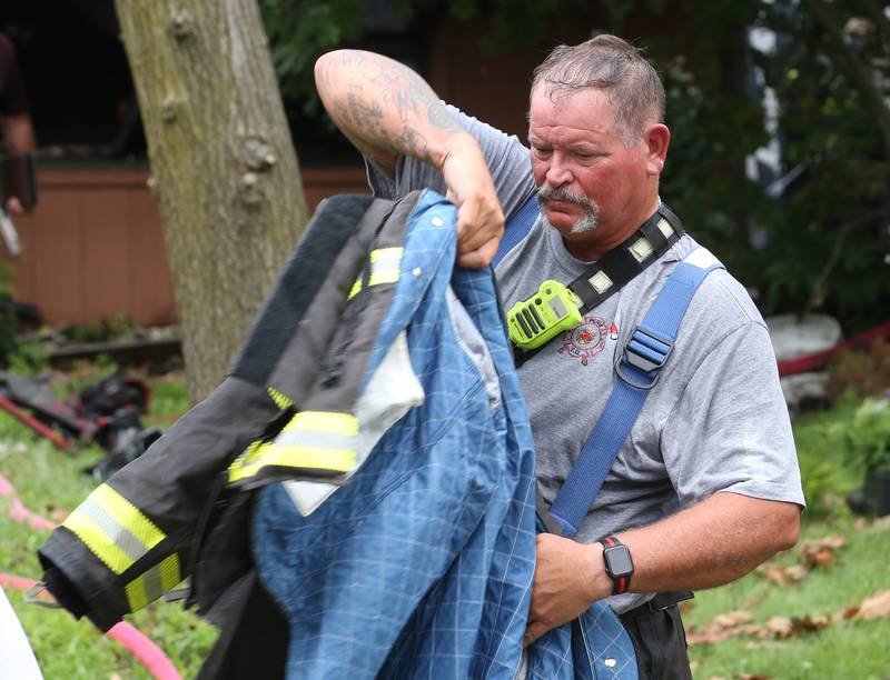 Peru Fire Chief Jeff King puts on his fire coat during a structure fire in the 500 block of North 2782nd Road on Monday, July 21, 2025 in La Salle. FIre departments from Utica, Wallace, Naplate, Spring Valley, Mendota, Troy Grove, La Salle, Peru, Oglesby and Tonica responded to the scene. Fire crews were dispatched at 9:45 a.m. La Salle Police and La Salle County Sheriff were also on the scene.