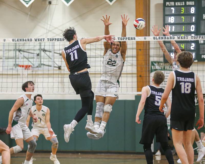 Downers Grove North's Aidan Akkawi (11) with a kill past the defense of Glenbard West's Xzavion Willett (22) during volleyball match between Downers Grove North at Glenbard West.  April 2, 2024.