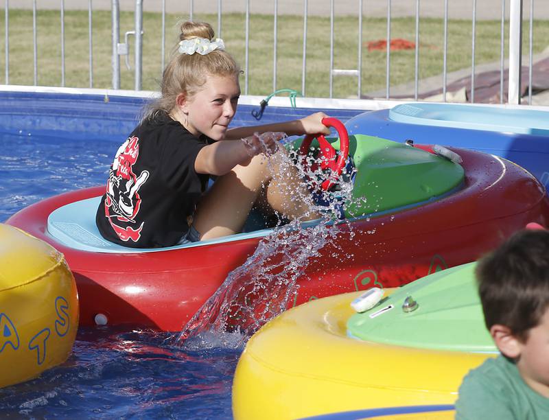 Scarlett Towry tries to splash a friend as she rides the bumper boats during the first day of the McHenry County Fair Tuesday, August 2, 2022, at the fairgrounds in Woodstock. The fair funs through Sunday, Aug. 7.  Entry to the fair is $10 for anyone over age 14, and $5 for chidden ages 6 to 13. Ages 5 and under are free.