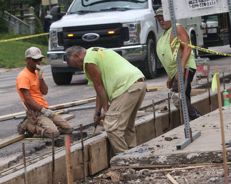 Workers replace a curb and a sidewalk near the intersection of 5th Street and Crosat Street on Monday, July 29, 2024 in La Salle. A long-term construction project is in full swing involving road patching, milling and resurfacing U.S. Route 6 from La Salle to Peru. In addition to roadwork, crews are rebuilding sidewalk ramps, drainage repairs, signal improvements and install raised reflectors. The 6.4 million project is expected to be fully completed by the end of summer 2025. Motorists are advised to use caution and be aware of traffic signals through the construction zones, which may cause increased wait times.