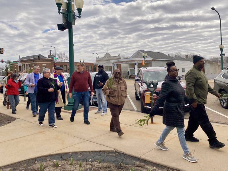 Participants hold signs during a procession at a Palm Sunday Faith Action event on Sunday, March 29, 2026, in front of the DeKalb County Courthouse in Sycamore. Area Christian ministers organized the event to combat the rise of Christian nationalism in the U.S.