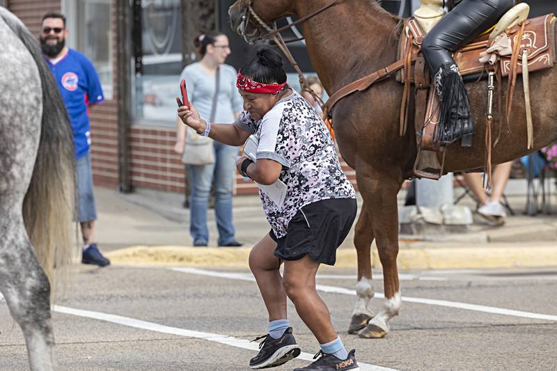 Carolina Flores of Rock Falls takes video and dances to some traditional Mexican music Saturday, Sept. 16, 2023 during the Sauk Valley Fiesta Days parade.