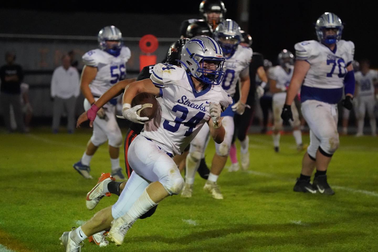 Woodstock's Stewart Reuter (34) carries the ball against Sandwich during a football game at Sandwich High School on Friday, Oct. 11, 2024.