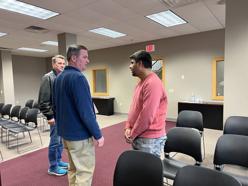 Ted Strack, a Sycamore Park District Commissioner that sits on the Sycamore Planning and Zoning Commission, looks on as John Sauter, the Sycamore director for Community Development, talks with Nehalkumar Patel, who hopes to open a convenience store at the location of a former 7-Eleven in the city's downtown, on March 11, 2024.