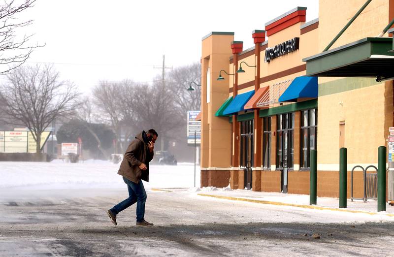 A shopper hustles through bitter cold toward Sullivan's Foods in Marengo Friday morning.
