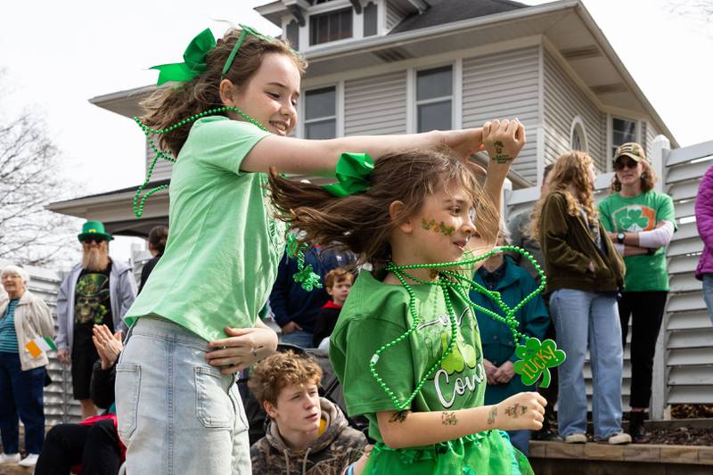 Kamryn Monroe, 11, spins Talie Lacava, 8, to music coming from the St. Charles St. Patrick’s Parade on Main Street in St. Charles on Saturday, March 15, 2025.