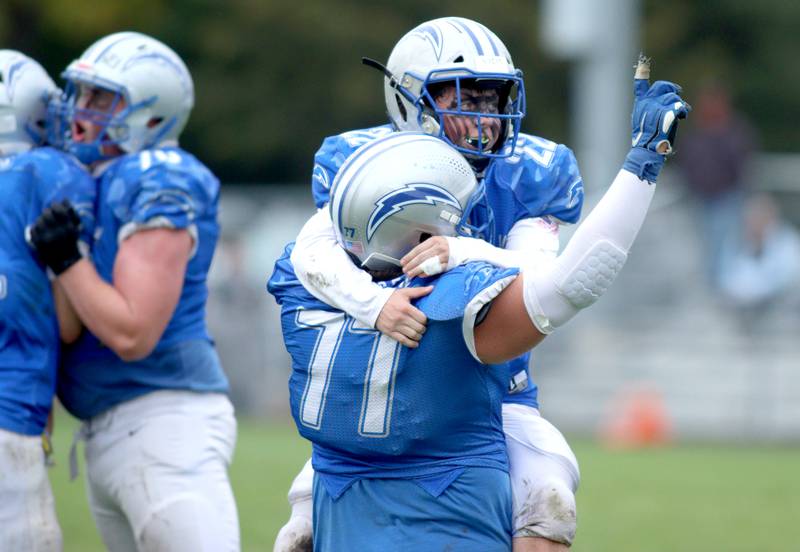 Woodstock’s Jackson Canty (22) and Bode Pedersen (77) celebrate late in a win over Ottawa in varsity football at Larry Dale Field on the campus of Woodstock High School Saturday.