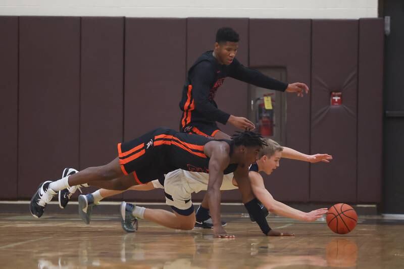 Lemont’s Matas Castillo dives for the ball against Romeoville’s Denonte Cunningham (23) and Kaharie Loggin (34) in the WJOL Thanksgiving Classic Championship in Joliet on Saturday.