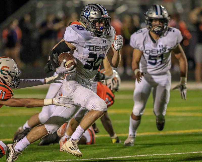Oswego East's Christian Martyn (30) takes off with the ball enroute to the endzone during varsity football game between Oswego East at Plainfield East.  Sept 8, 2022