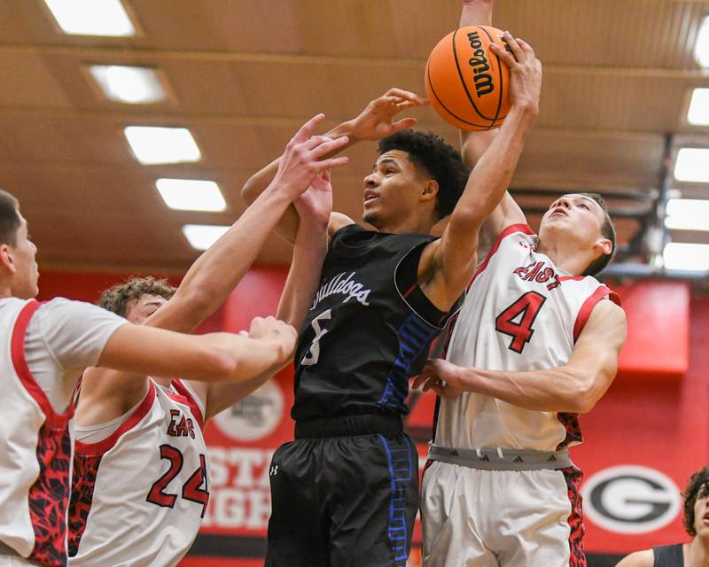 Riverside Brookfield's Cameron Mercer (5) gets a rebound while being defended by Glenbard East's Sam Walton (24) and Glenbard East's Michael Nee (4) during the game on Friday Dec. 19, 2025, held at Glenbar