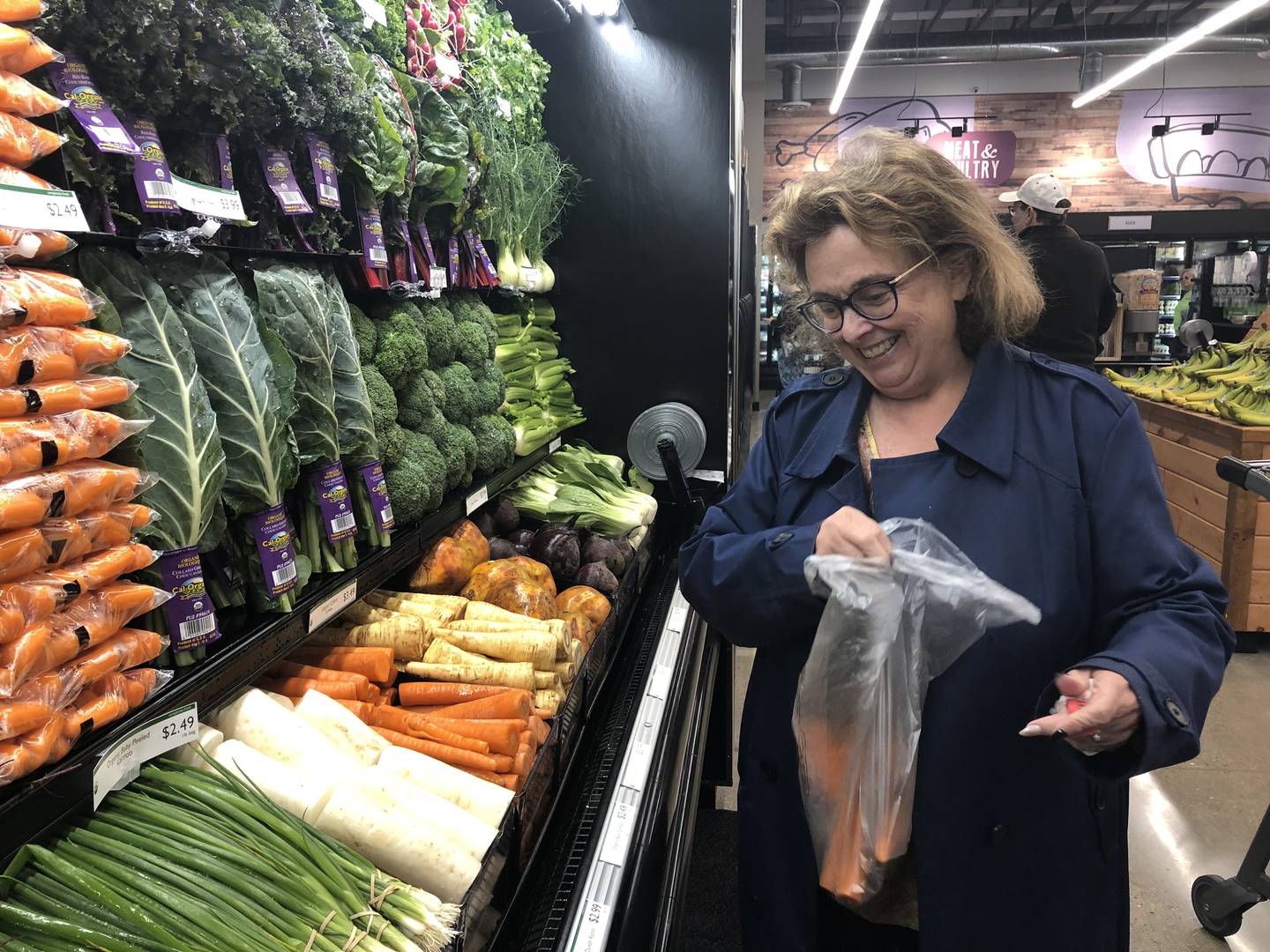 Tina Hill selects produce at the grand opening of the Food Shed Co-op in Woodstock on May 15, 2024.