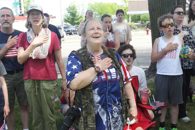 Cynthia Johnson, of Island Lake (center), watches the American flag being raised Monday, May 29, 2023, at Memorial Park during the Wauconda Memorial Day Ceremony.