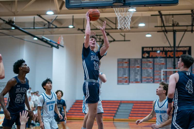 Oswego East's Ryan Johnson (12) shoots the ball in the post against Downers Grove South during the hoops for healing basketball tournament at Naperville North High School on Monday, Nov 21, 2022.