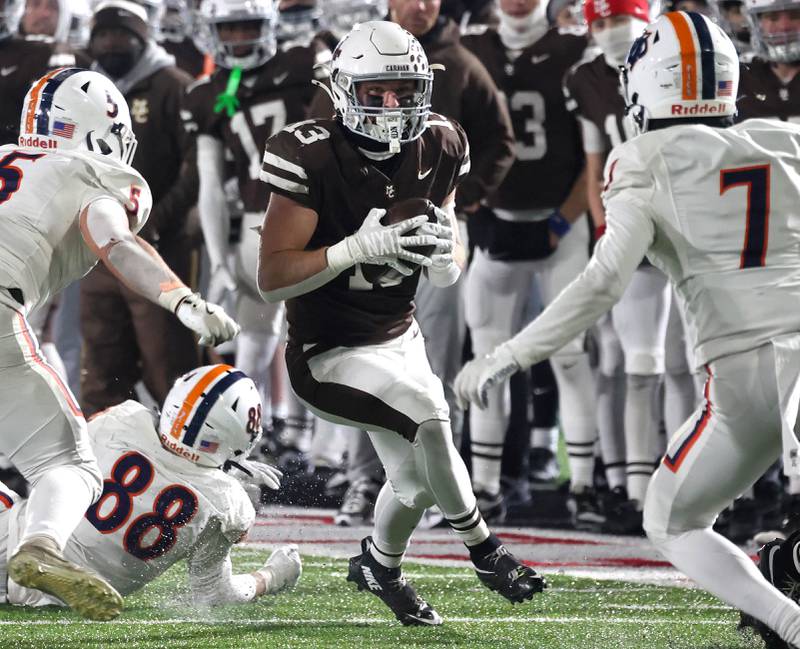 Mount Carmel's Dean Kemph tries to get between two Oswego defenders Wednesday, Dec. 3, 2025, during the IHSA Class 8A state chamionship game in Huskie Stadium at Northern Illinois University in DeKalb.