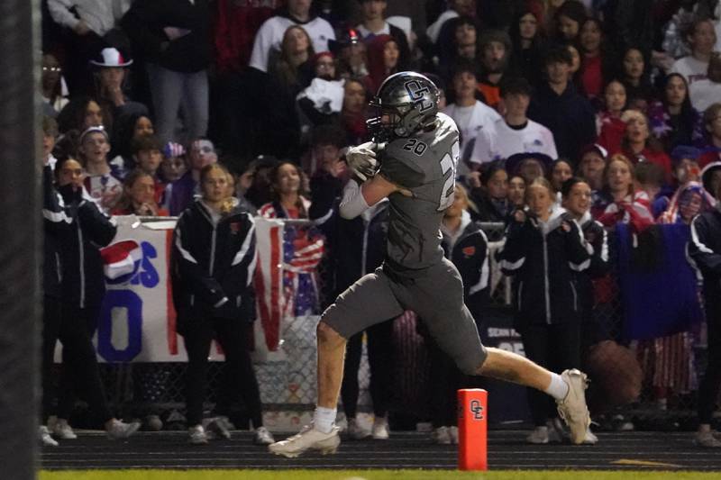 Oswego East's Andrew Pohlman (20) scores a touchdown against Oswego during a football game at Oswego East High School on Friday, October 25, 2024.