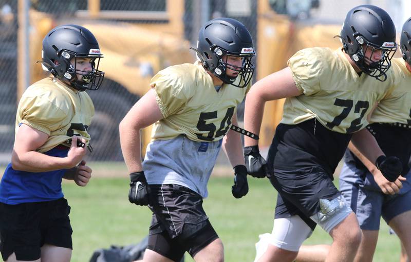 Sycamore offensive linemen run up to the line of scrimmage for a play during practice Monday, July 17, 2023 at the school.