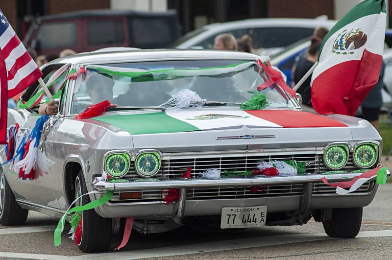 A lowrider, decked out in the colors of the Mexican flag, rolls through the Fiesta Parade Saturday in Sterling and Rock Falls.