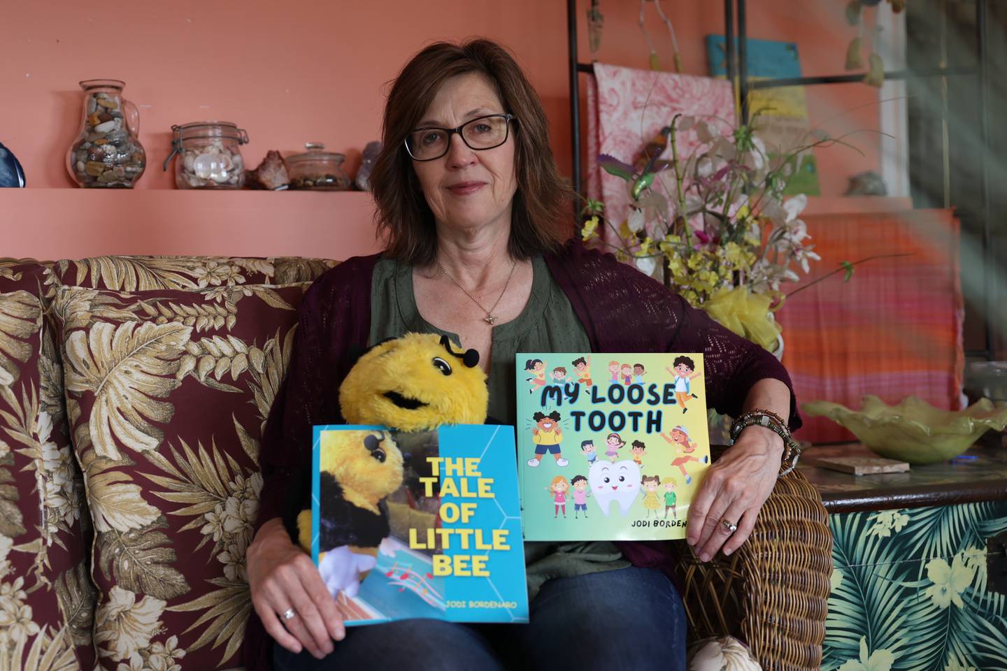 Jodie Bordenero poses for a photo with her two published books, including one of a bee puppet on Tuesday, June 27th, 2023 in Lockport.