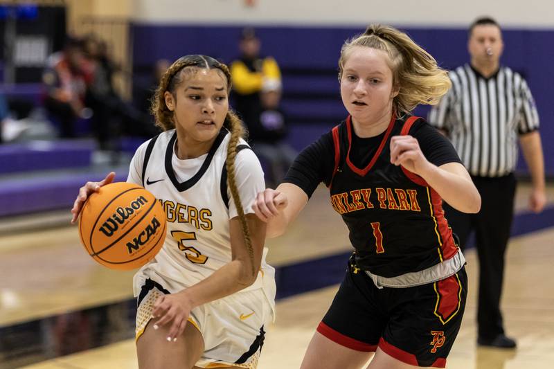 Joliet West's Niyonna Reddington drives to the basket as Tinley Park's Corah Horbaczewski defends during a WJOL Girls Basketball Tournament game at Joliet Junior College on Nov. 18, 2025.