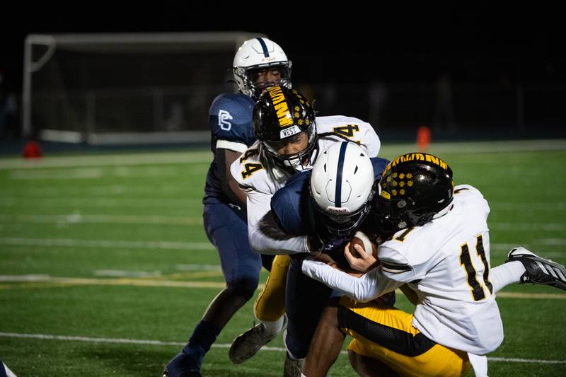 Plainfield South's Cody Hogan is brought down by Joliet West's DaVante Morrow and Sedrick Love during a game  Friday Oct. 4, 2024 at Plainfield South High School