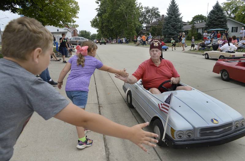 The Red Fez Shrine Club shakes hands Sunday, Aug. 14, 2022, with those along Walnut Street during the Wenona Days parade.
