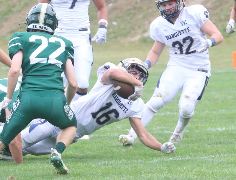 Marquette's Payton Gutierrez lunges for a few extra yards over St. Bede's Ryan Nawa during the Homecoming game on Saturday, Sept. 28, 2024 at St. Bede Academy.
