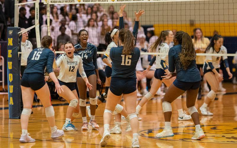 Oswego East players celebrate after scoring a point against Neuqua Valley during the Neuqua Valley 4A regional final volleyball match at Neuqua Valley High School in Naperville on Thursday, Oct 27, 2022.