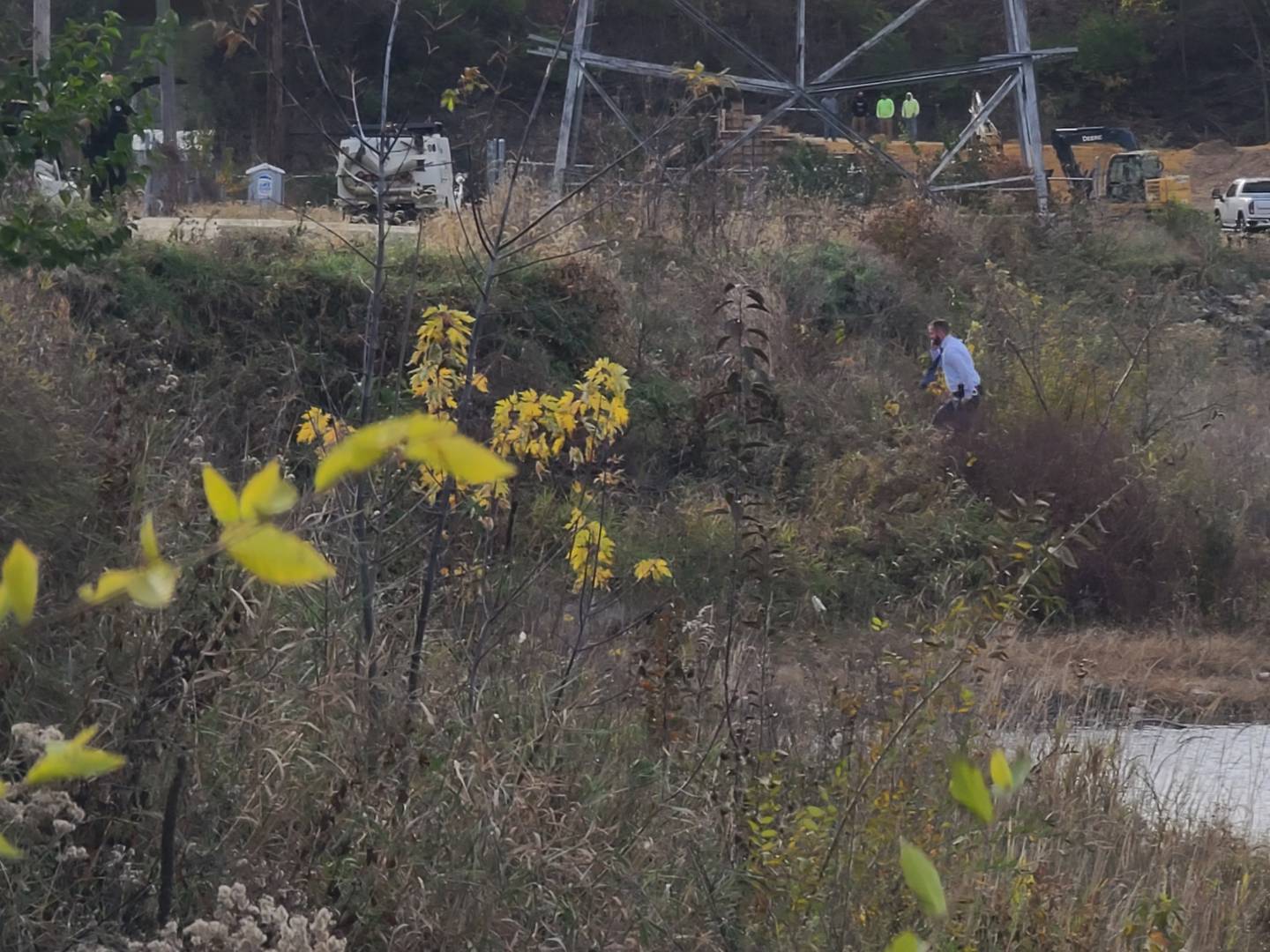 Authorities walk along the Rock River's shoreline near Dixon's Peoria Avenue bridge on Tuesday as they investigate the discovery of a body.