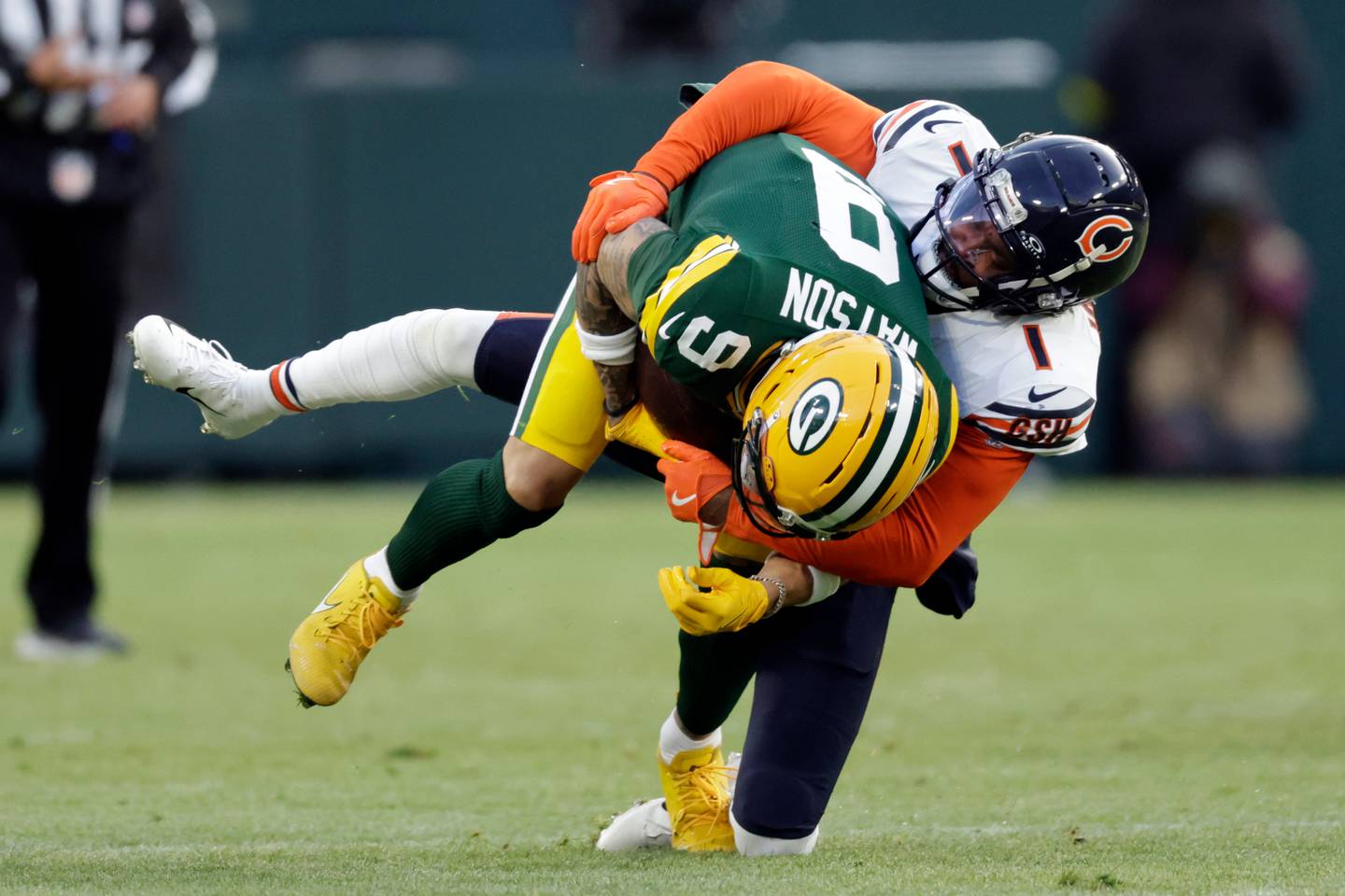 Chicago Bears cornerback Jaylon Johnson (1) tackles Green Bay Packers wide receiver Christian Watson (9) during the first half of an NFL football game Sunday, Dec. 7, 2025, in Green Bay, Wis. (AP Photo/Matt Ludtke)