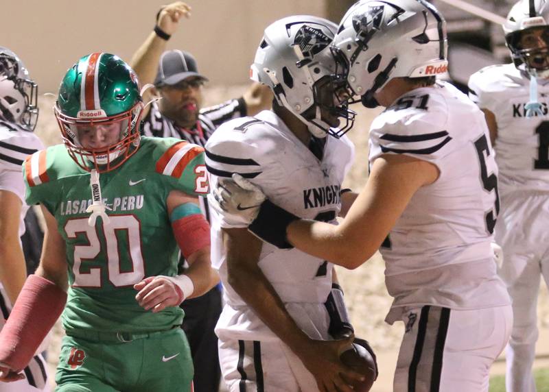 Kaneland quarterback Jalen Carter (center) celebrates with teammate Alex Alvarez after scoring a touchdown against L-P on Friday, Oct. 17, 2025 at Howard Fellows Stadium.