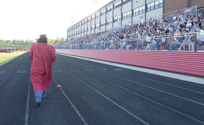 The last graduate enters King Field before the packed stands Friday, May 26, 2023, at Ottawa High School.