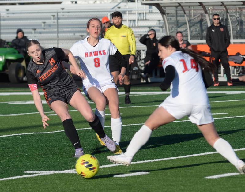 Oregon's Sophia Stombaugh (14) stretches for the ball as her teammate Addison Rufer (8) and  Freeport's Gracie Whitham (14) move in on the play during a game on Monday, March 31, 2025 at Freeport High School.
