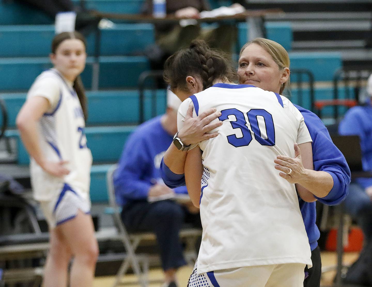 Geneva's Keira McCann is hugged by Geneva Head Coach Sarah Meadows after Geneva lost to St. Viator in the IHSA Class 3A Woodstock North Supersectional girls basketball game on Monday, March 2, 2026, at Woodstock North High School.
