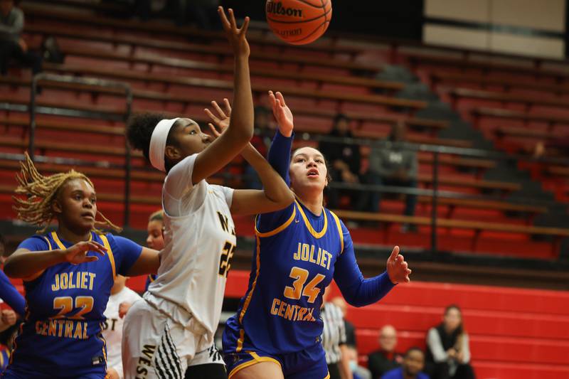 Joliet West’s Makayla Chism and Joliet Central’s Nylah Davis reach for a rebound in the Class 4A Bradley-Bourbonnais Regional semifinals on Monday, February 13, 2023.