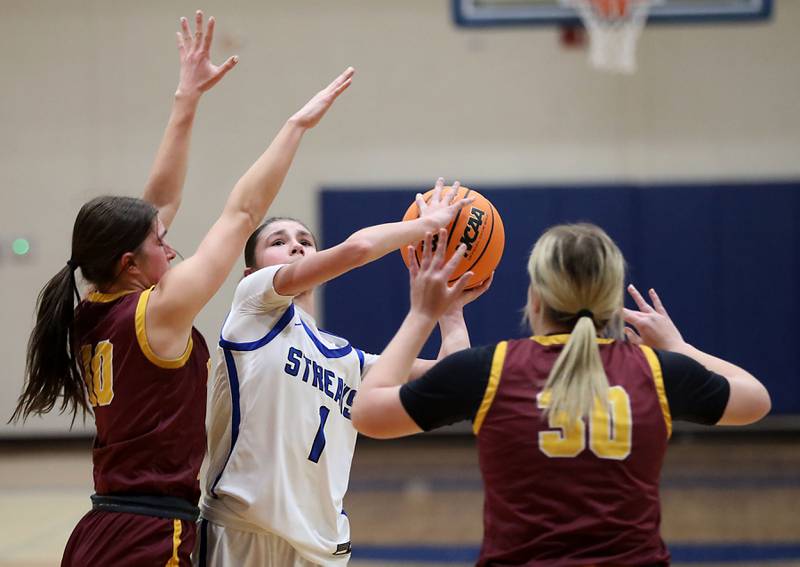 Woodstock's Alex Nowacki (center) tries to shoot the ball between Richmond-Burton's Daniella Mazzola (left) and Chase Cooper (right)during a Kishwaukee River Conference girls basketball game on Wednesday, Jan. 28, 2026, at Woodstock High School.