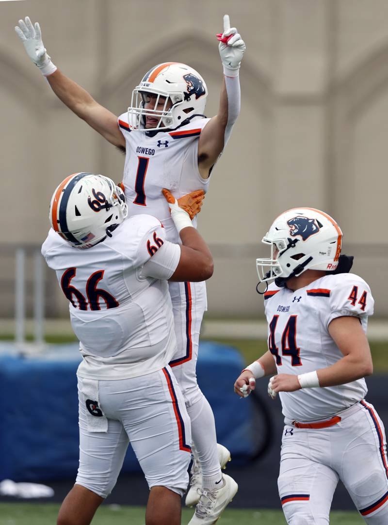 Oswego's Teddy Manikas (1) is lifted up in celebration by Khristopher Villalbazo (66) after scoring during the varsity football second-round 8A playoff game between Oswego and Lane Tech on Saturday, Nov. 8, 2025 in Chicago.