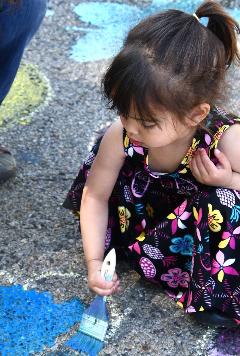 Darah Martinkus colors art Saturday, May 28, 2023, on the street during Sidewalk Chalkapalooza at Soldiers and Sailors Park in Princeton.